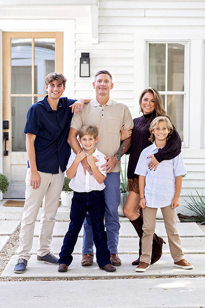 Family of five standing together outside The Beverly-Harris House during a fall family photography session in McKinney, Texas.