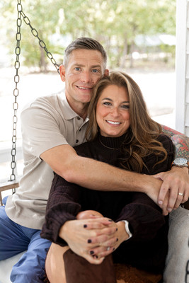 Couple sitting together on a porch swing and smiling during a fall family photography session at The Beverly-Harris House in McKinney, Texas.